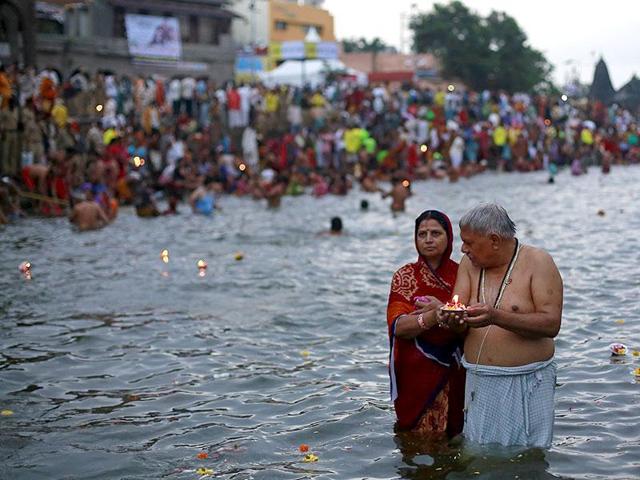 Hindu devotees pray while standing in the Godavari river during Kumbh Mela.(Reuters)
