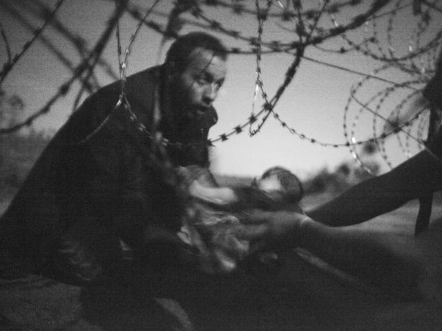 The World Press Photo of the Year titled "Hope for a new Life" by photographer Warren Richardson. The picture also won a first prize in the Spot News singles category and shows a man passing a baby through the fence at the Serbia-Hungary border in Roszke, Hungary, Aug. 28, 2015. (Warren Richardson/ AP) The World Press Photo of the Year titled "Hope for a new Life" by photographer Warren Richardson. The picture also won a first prize in the Spot News singles category and shows a man passing a baby through the fence at the Serbia-Hungary border in Roszke, Hungary, Aug. 28, 2015. (Warren Richardson/ AP)