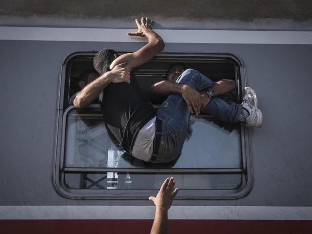 In this image released by World Press Photo titled "Reporting Europe's Refugee Crisis" by photographer Sergey Ponomarev for The New York Times which won the first prize in the General News Stories category shows refugees attempting to board a train headed to Zagreb, Croatia in Tovarnik, Croatia, 18 September 2015. (Sergey Ponomarev for The New York Times, World Press Photo via AP) (Sergey Ponomarev/ NYT/ AP) In this image released by World Press Photo titled "Reporting Europe's Refugee Crisis" by photographer Sergey Ponomarev for The New York Times which won the first prize in the General News Stories category shows refugees attempting to board a train headed to Zagreb, Croatia in Tovarnik, Croatia, 18 September 2015. (Sergey Ponomarev for The New York Times, World Press Photo via AP) (Sergey Ponomarev/ NYT/ AP)