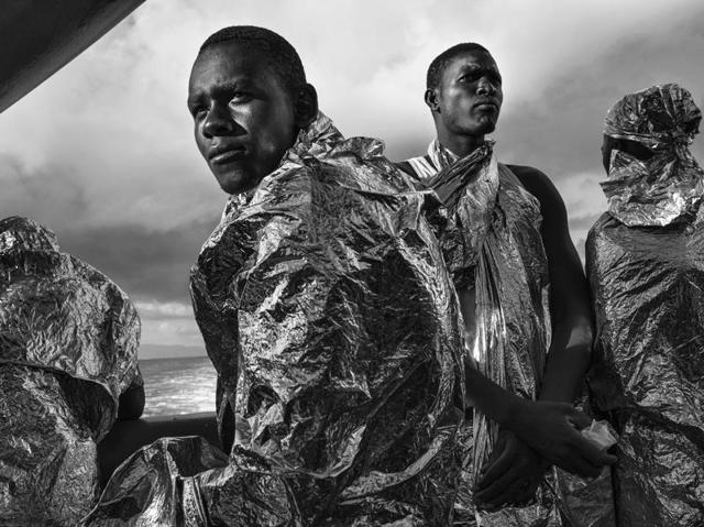 In this image released by World Press Photo titled "In the Same Boat" by photographer Francesco Zizola for Noor agency which won the second prize in the Contemporary Issues category shows migrants wrapped in emergency blankets two days after being rescued catch sight of the Italian coast for the first time, Strait of Sicily, Mediterranean Sea, Aug. 23, 2015. (Francesco Zizola/Noor, World Press Photo via AP) (AP) In this image released by World Press Photo titled "In the Same Boat" by photographer Francesco Zizola for Noor agency which won the second prize in the Contemporary Issues category shows migrants wrapped in emergency blankets two days after being rescued catch sight of the Italian coast for the first time, Strait of Sicily, Mediterranean Sea, Aug. 23, 2015. (Francesco Zizola/Noor, World Press Photo via AP) (AP)