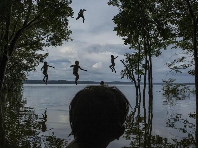 In this image released by World Press Photo titled "Amazon's Munduruku Tribe" by photographer Mauricio Lima for The New York Times which won second prize in the Daily Life singles category shows indigenous Munduruku children playing in the Tapajos river in the tribal area of Sawre Muybu, Itaituba, Brazil, Feb. 10, 2015. The tribesmen of the Munduruku, who for centuries have sanctified the Tapajos River on which their villages sit, are fighting for survival. Brazil’s government plans to flood much of their land to build a $9.9 billion hydroelectric dam, the Sao Luiz do Tapajos, as part of a wider energy strategy across the Amazon rainforest. (Mauricio Lima/The New York Times, World Press Photo via AP) (AP) In this image released by World Press Photo titled "Amazon's Munduruku Tribe" by photographer Mauricio Lima for The New York Times which won second prize in the Daily Life singles category shows indigenous Munduruku children playing in the Tapajos river in the tribal area of Sawre Muybu, Itaituba, Brazil, Feb. 10, 2015. The tribesmen of the Munduruku, who for centuries have sanctified the Tapajos River on which their villages sit, are fighting for survival. Brazil’s government plans to flood much of their land to build a $9.9 billion hydroelectric dam, the Sao Luiz do Tapajos, as part of a wider energy strategy across the Amazon rainforest. (Mauricio Lima/The New York Times, World Press Photo via AP) (AP)