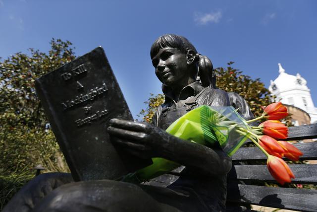 Flowers are placed on a statue of a girl reading Harper Lee's To Kill a Mockingbird outside a memorial for Lee in Monroeville. (AP) Flowers are placed on a statue of a girl reading Harper Lee's To Kill a Mockingbird outside a memorial for Lee in Monroeville. (AP)