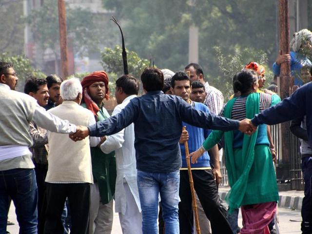 Locals form a human chain to tackle Jats protesting in Rohtak demanding quota in government jobs and educational institutions.(AFP)