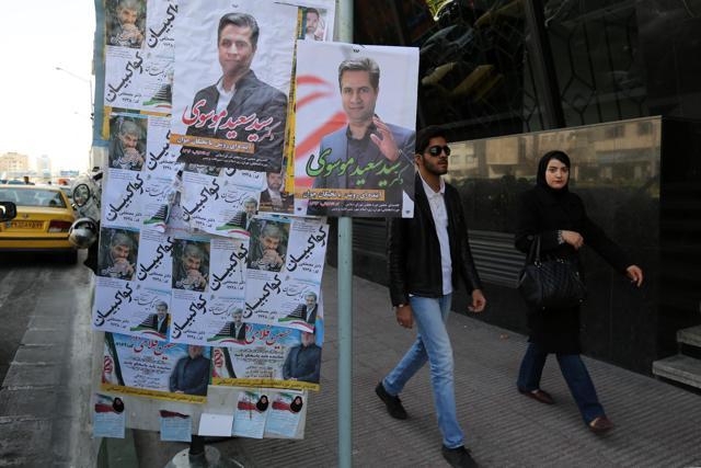 Iranian women walk past campaign posters bearing portraits of candidates for the upcoming parliamentary elections, including Saeed Mousavi. (AFP) Iranian women walk past campaign posters bearing portraits of candidates for the upcoming parliamentary elections, including Saeed Mousavi. (AFP)