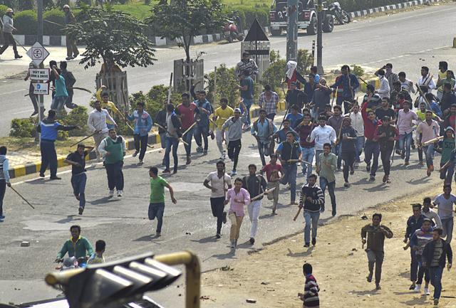 Protesters run some with sticks during a quota protest in Rohtak, 70 kilometers (45 miles) west of New Delhi. (AP Photo) Protesters run some with sticks during a quota protest in Rohtak, 70 kilometers (45 miles) west of New Delhi. (AP Photo)