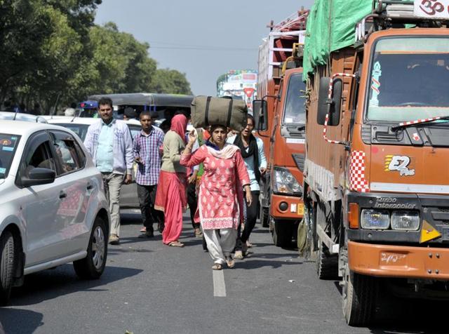 People walking during a blockade by Jat protesters at Ladsoli village in Sonepat district on Monday.(Ravi Kumar/HT)