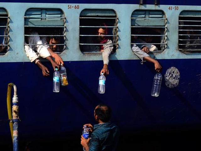 Thirst-quenching: Passengers pass their bottles through the windows to fill them with water at a station in Allahabad. Temperatures in the city hover around 40 degrees Celsius in Summer. (Sheeraz Rizvi/ HT Photo) 