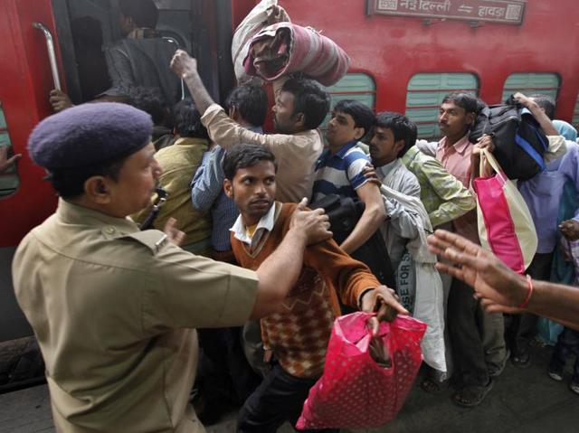 Fall in line: Police  officials helping passengers to board the Bihar Sampark Kranti train as there is a heavy rush at New Delhi Railway Station due to Chhath pooja festival . (Raj k Raj/HT Photo) 