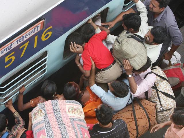 Emergency entry : A man is trying to push his son through the emergency window, as there is a long queue to board the Sapt Kranti Express which connects New Delhi and Muzaffarpur. (Arvind Yadav/HT Photo) 