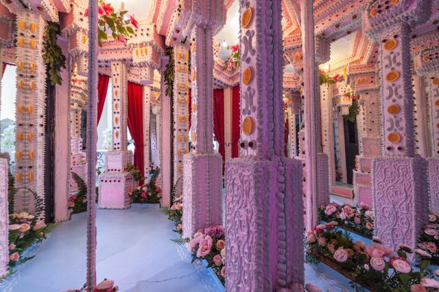 Spanning across the ceiling and wrapping around architectural beams, the acrylic frosted works are replete with glistening rhinestones, stiletto heels, and sharp fangs, integrated into each installation. (Twitter)