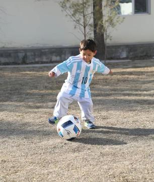 Murtaza Ahmadi playing football and wearing the jersey sent for him by Lionel Messi. (Unicef Afghanistan) Murtaza Ahmadi playing football and wearing the jersey sent for him by Lionel Messi. (Unicef Afghanistan)