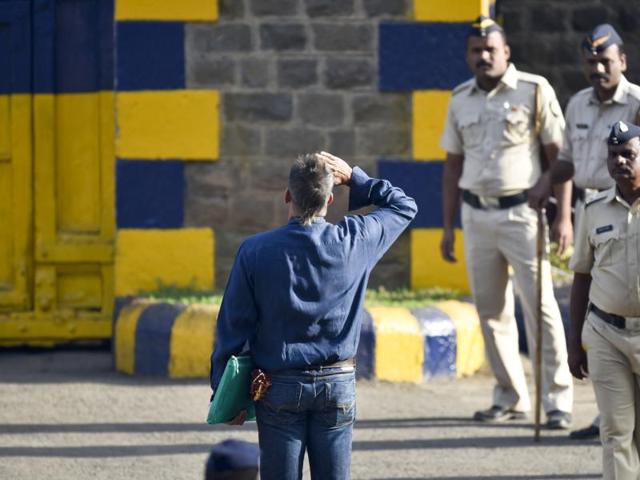 Sanjay Dutt is watched by officials as he salutes the Indian flag at the entrance to Pune’s Yerwada jail. (Satish Bate/HT Photo) 
