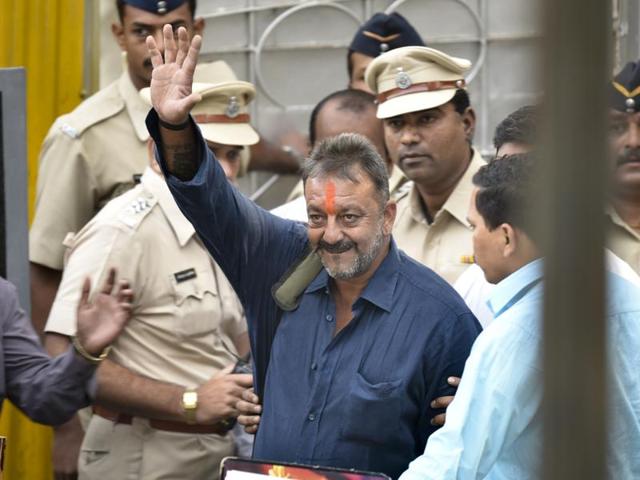Bollywood actor Sanjay Dutt waves as he is escorted by officials from Yerwada jail in Pune on February 25, 2016. (Satish Bate/ HT Photo) 