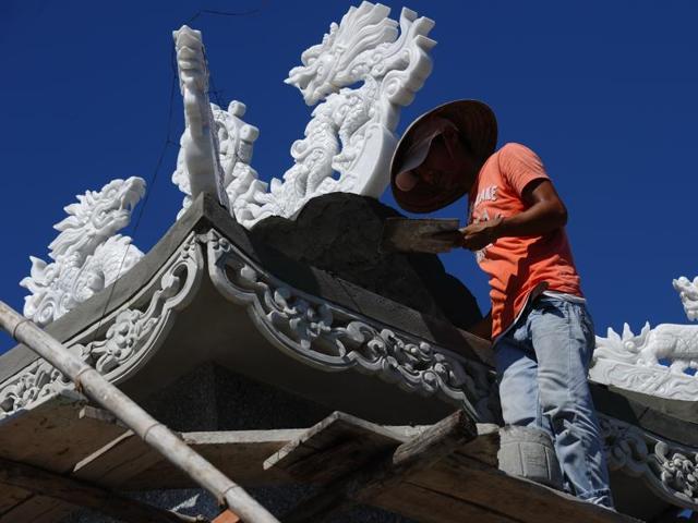 A worker building a $40,000 USD family tomb at a cemetery. It is an astronomical cost considering that the country’s annual per capital income is $2,000.  (AFP) 