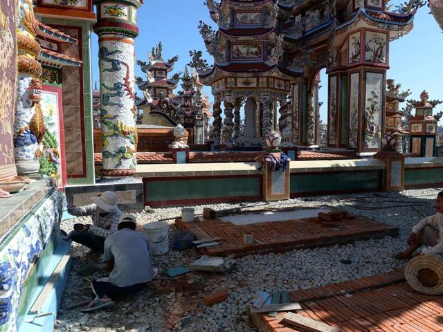 Workers decorating a family tomb at a cemetery. Retired fisherman Dang Thien, for instance, was one of the first ones in 1994 to renovate his family plot into elaborate cemetery. Since then, locals have been investing heavily in centuries-old cemeteries.  (AFP) 