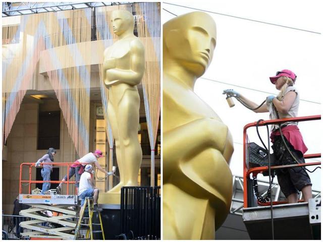 The huge statue of the Oscar getting polished and painted by workers. (Facebook) 