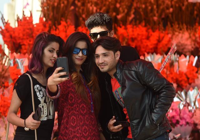 Pakistani visitors take a 'selfie' at flower market in Islamabad. (AFP)