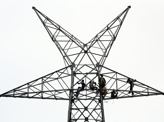Workers repair electric cables. Power tariffs may be in for rationalisation. (AFP/file) Workers repair electric cables. Power tariffs may be in for rationalisation. (AFP/file)
