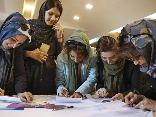 Iranian voters fill out their ballots during the parliamentary and Experts Assembly elections in a polling station in Tehran, Iran.(AP Photo)