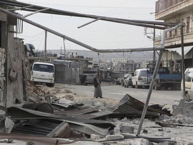 A man walks near damage in Kafr Hamra village, northern Aleppo countryside in Syria. (Reuters Photo)