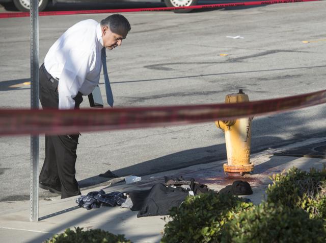 Detective J.D Duran, right, and Anaheim Police Department forensics officerJeannette Torres investigate the scene in Anaheim, Calif., Saturday, Feb.27, 2016, after a small group of Ku Klux Klan members staging an anti-immigrant rally clashed with a larger gathering of counter-protesters. (AP) Detective J.D Duran, right, and Anaheim Police Department forensics officerJeannette Torres investigate the scene in Anaheim, Calif., Saturday, Feb.27, 2016, after a small group of Ku Klux Klan members staging an anti-immigrant rally clashed with a larger gathering of counter-protesters. (AP)