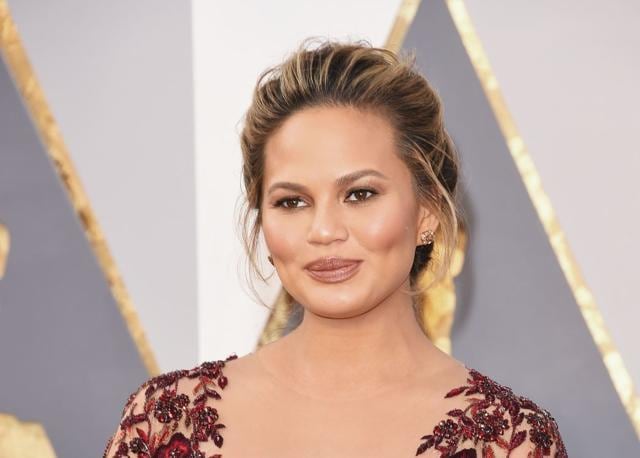 Chrissy Teigen showed off champagne-tinted diamonds on her earrings and on her rings, which were worth an impressive $2.8 million. (AFP)