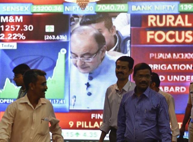 Office-goers walk past a digital screen showing finance minister Arun Jaitley delivering his Budget speech at Parliament in New Delhi on February 29, 2016.(Kunal Patil/HT Photo)