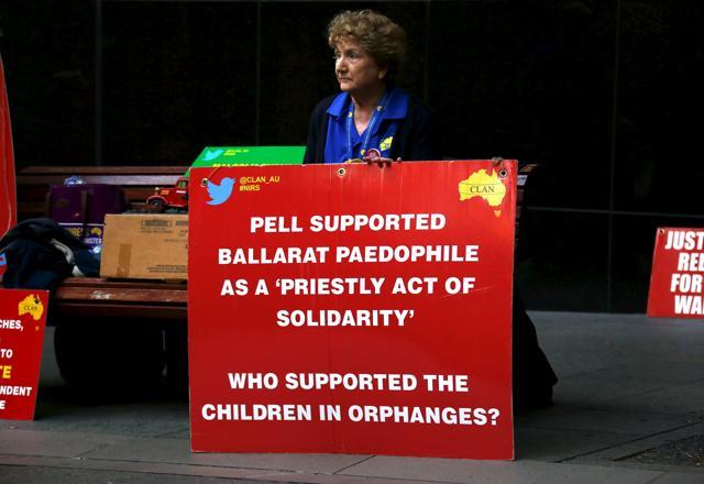 A relative of children who were sexually abused by the Catholic Church holds a placard as she sits outside the venue for Australia's Royal Commission into Institutional Response to Child Sexual Abuse in Sydney. (REUTERS)