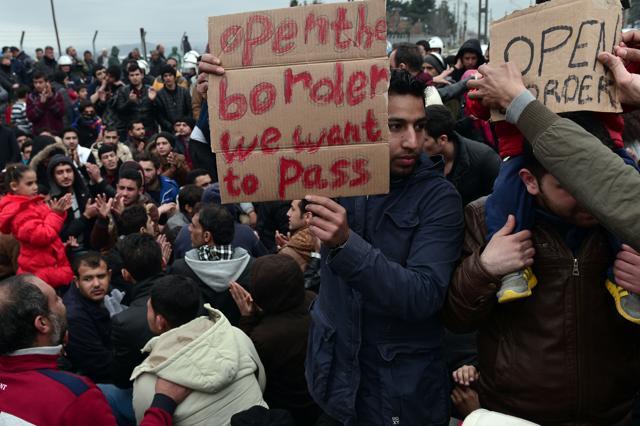 Syrian and Iraqi refugees trapped at the Greek-Macedonian border protest. (AFP)