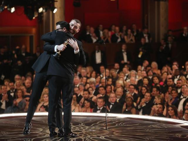Jimmy Napes, left, and Sam Smith as seen from backstage as they hug it out after accepting the award for best original song for Writing’s On The Wall for Spectre at the Oscars. (AP) Jimmy Napes, left, and Sam Smith as seen from backstage as they hug it out after accepting the award for best original song for Writing’s On The Wall for Spectre at the Oscars. (AP)