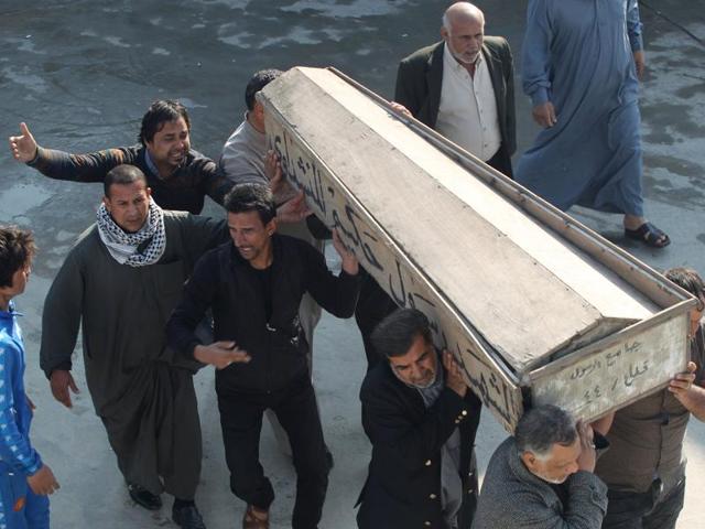 Mourners react over the coffin of their relative, who was killed in a bomb attack in Baghdad, during the funeral in Najaf, south of Baghdad, February 29, 2016.(REUTERS)