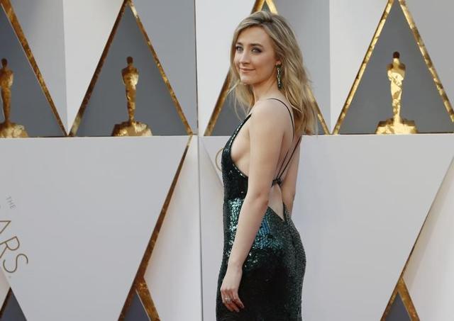 Saoirse Ronan, nominated for Best Actress for her role in Brooklyn, arrivesemerald Calvin Klein dress with an open back and dramatic V-neck. Saoirse Ronan, nominated for Best Actress for her role in Brooklyn, arrivesemerald Calvin Klein dress with an open back and dramatic V-neck.