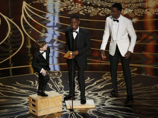 Host Chris Rock brings out apple boxes for young presenters Jacob Tremblay and Abraham Attah to reach the microphone at the 88th Academy Awards in Hollywood. (REUTERS) Host Chris Rock brings out apple boxes for young presenters Jacob Tremblay and Abraham Attah to reach the microphone at the 88th Academy Awards in Hollywood. (REUTERS)