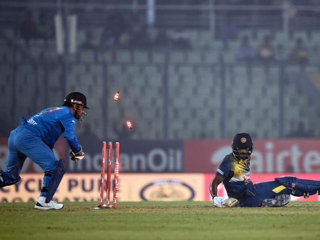 India's captain Mahendra Singh Dhoni (L) successfully stumps Thisara Perera (R). (AFP Photo) 