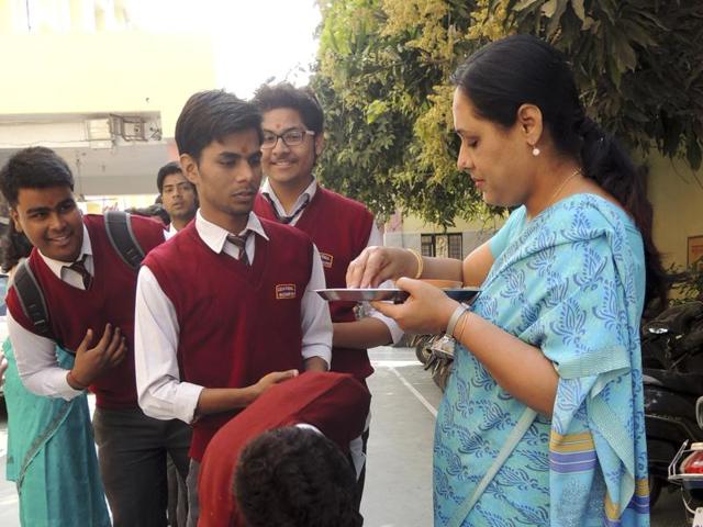 School teachers wish luck to CBSE examinees by applying a traditional ‘tilak’ and offering sweets outside an examination hall in Lucknow on Tuesday. (Deepak Gupta/HT photo) School teachers wish luck to CBSE examinees by applying a traditional ‘tilak’ and offering sweets outside an examination hall in Lucknow on Tuesday. (Deepak Gupta/HT photo)