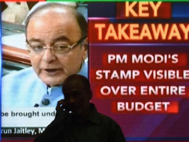 An office worker walks past a digital screen at the Bombay Stock Exchange (BSE) in Mumbai showing finance minister Arun Jaitley delivering the budget speech in Parliament. (AFP Photo) An office worker walks past a digital screen at the Bombay Stock Exchange (BSE) in Mumbai showing finance minister Arun Jaitley delivering the budget speech in Parliament. (AFP Photo)