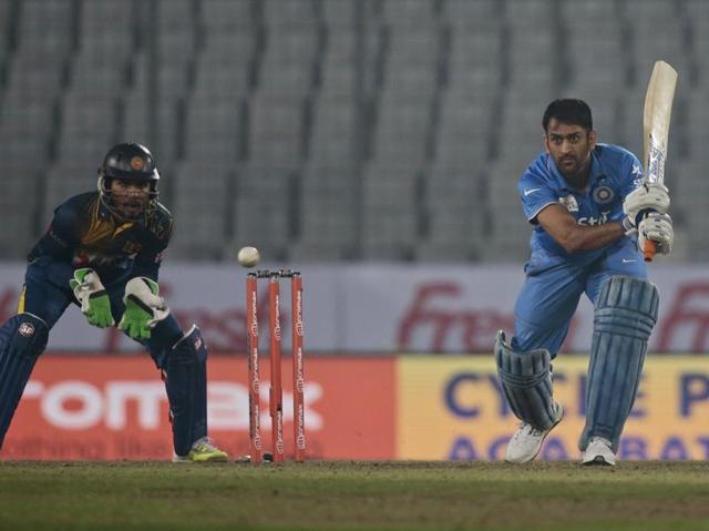 India’s captain Mahendra Dhoni, right, plays a shot, as Sri Lanka's wicketkeeper Dinesh Chandimal follows the ball during their Asia Cup Twenty20 international cricket match. (AP Photo) 