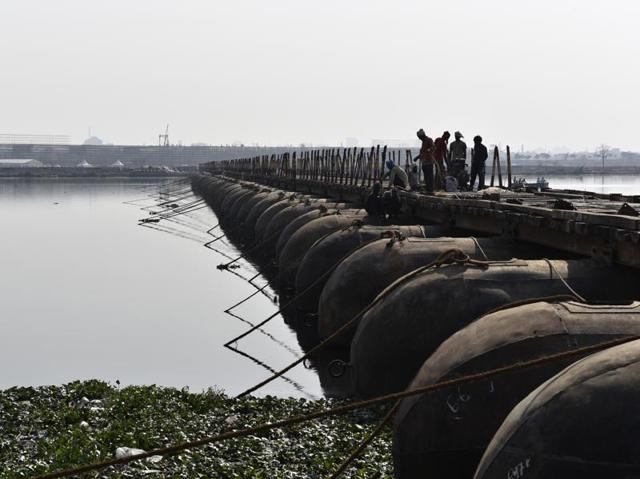 A bridge being constructed for visitors across the Yamuna. The NGT in a detailed judgment last year expressly prohibited all construction activity on the floodplains as that could pose a grave danger to the river ecology. The tribunal had asked its principal committee to identify structures on the floodplains that needed to be demolished. (Saumya Khandelwal/HT Photo) A bridge being constructed for visitors across the Yamuna. The NGT in a detailed judgment last year expressly prohibited all construction activity on the floodplains as that could pose a grave danger to the river ecology. The tribunal had asked its principal committee to identify structures on the floodplains that needed to be demolished. (Saumya Khandelwal/HT Photo)