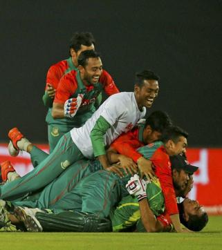 Bangladesh’s Mahmudullah, on ground, and teammates celebrate after defeating Pakistan by 5 wickets. (AP)
