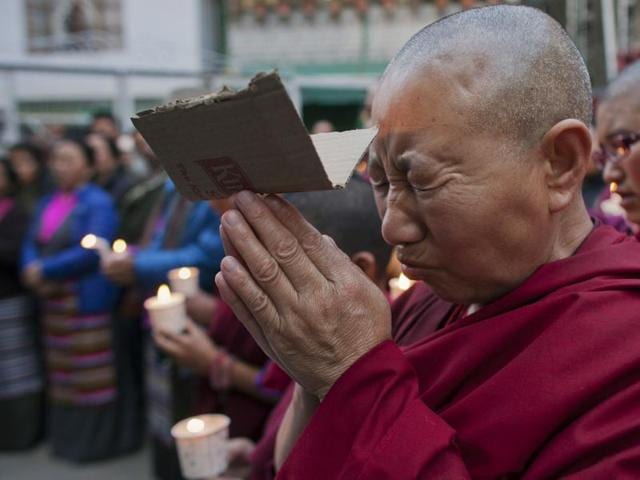 An exiled Tibetan carries a portrait of the Dalai Lama while another holds a poster with portraits of two Tibetans who exiles claim immolated themselves demanding freedom for Tibet, during a candle-light vigil in Dharmsala on Wednesday.(AP) An exiled Tibetan carries a portrait of the Dalai Lama while another holds a poster with portraits of two Tibetans who exiles claim immolated themselves demanding freedom for Tibet, during a candle-light vigil in Dharmsala on Wednesday.(AP)