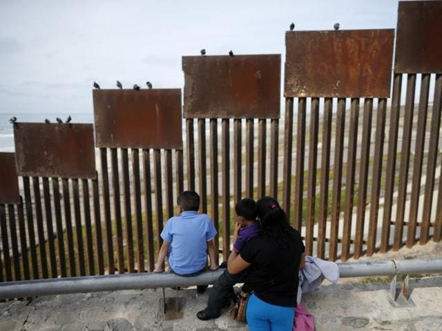A family looks towards metal bars marking the United States border where it meets the Pacific Ocean in Tijuana, Mexico. (AP) A family looks towards metal bars marking the United States border where it meets the Pacific Ocean in Tijuana, Mexico. (AP)