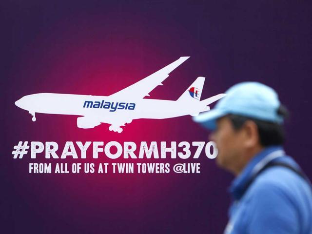 A tourist walks past a signboard saying ‘Pray for MH370’ near Kuala Lumpur City Center. (Reuters file) A tourist walks past a signboard saying ‘Pray for MH370’ near Kuala Lumpur City Center. (Reuters file)