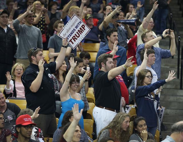 People raise their arms as Republican presidential candidate Donald Trump ask them to pledge that they will vote for him during a campaign rally. (AFP) People raise their arms as Republican presidential candidate Donald Trump ask them to pledge that they will vote for him during a campaign rally. (AFP)