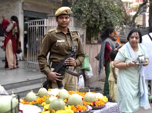 Jyoti, a 29-year-old cop stands guard outside a Mandir while others celebrate Maha Shivratri in Delhi. (Arun Sharma/HT Photo)