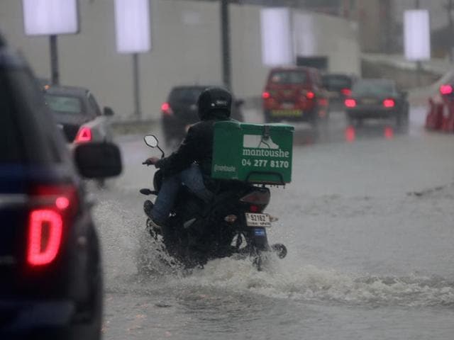 A delivery man rides his bike during heavy rain in Dubai. (AP) A delivery man rides his bike during heavy rain in Dubai. (AP)
