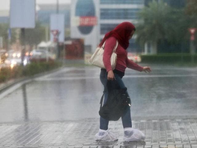 A woman covers her shoes with plastic bags as she walks in the rain in Dubai, United Arab Emirates. (AP) A woman covers her shoes with plastic bags as she walks in the rain in Dubai, United Arab Emirates. (AP)