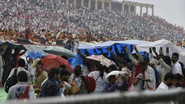 People are seen covering themselves with umbrellas and plastic sheets at the World Culture Festival venue in New Delhi. (Arvind Yadav/HT) People are seen covering themselves with umbrellas and plastic sheets at the World Culture Festival venue in New Delhi. (Arvind Yadav/HT)