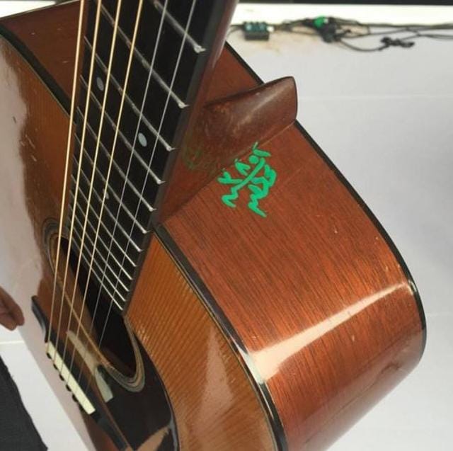 A number and an illegible word in Arabic had been scrawled in green ink on the guitar’s mahogany side. (Bryanadamsofficial/Facebook)