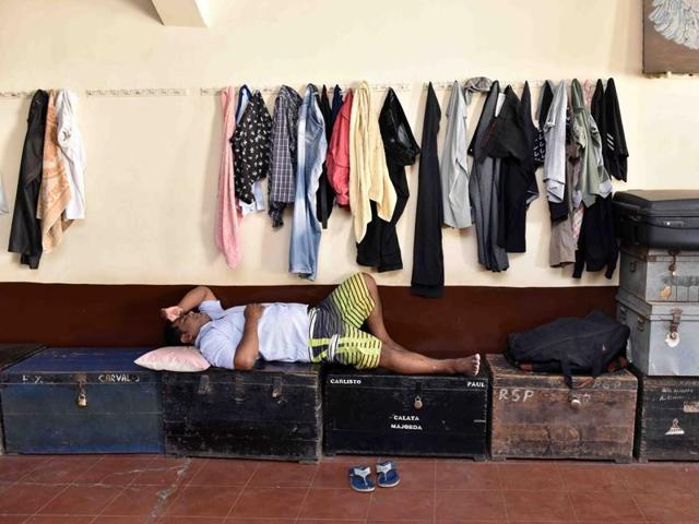 A young man rests on a row of trunks at the Club of Majorda , in Jer Mahal, Dhobi Talao. Beds are not allowed.   (Pratham Gokhale/ Hindustan Times) 
