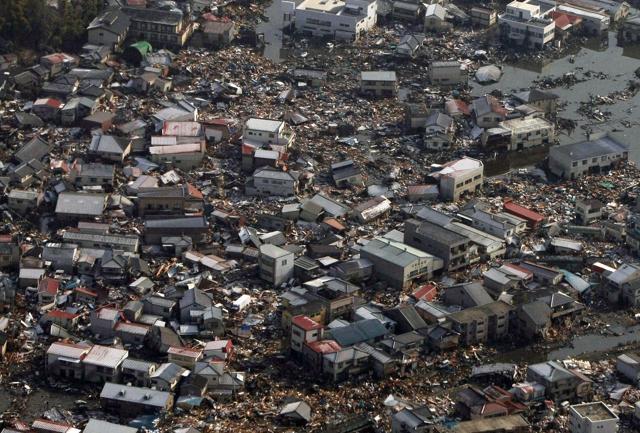 Collapsed houses and debris in a field in Kesennuma, Miyagi prefecture on March 12, 2011. (AFP File Photo)